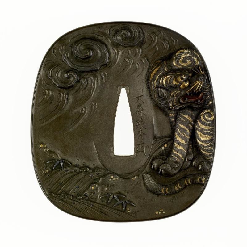 Tsuba with a Tiger and Dragon – Omori Teruhide 
On the front of the tsuba, a lion crouches ...