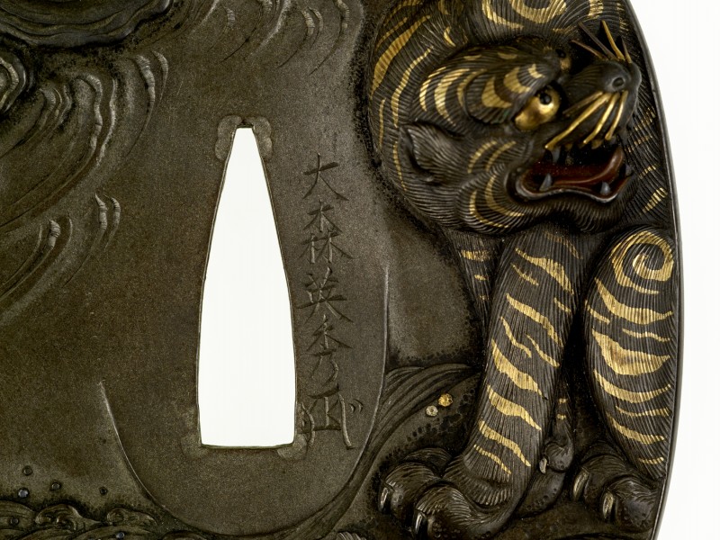 Tsuba with a Tiger and Dragon – Omori Teruhide 
On the front of the tsuba, a lion crouches ...