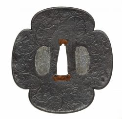 A Nobuie iron tsuba. Edo period, around 1600

Of mokkô shape, with a slight raised rim and karak ...