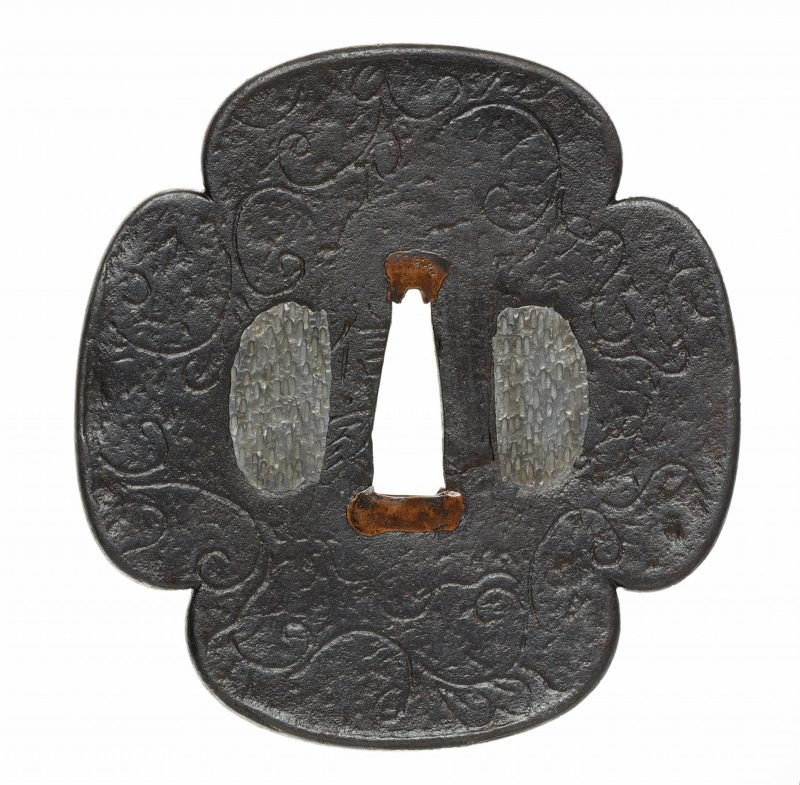 A Nobuie iron tsuba. Edo period, around 1600

Of mokkô shape, with a slight raised rim and karak ...