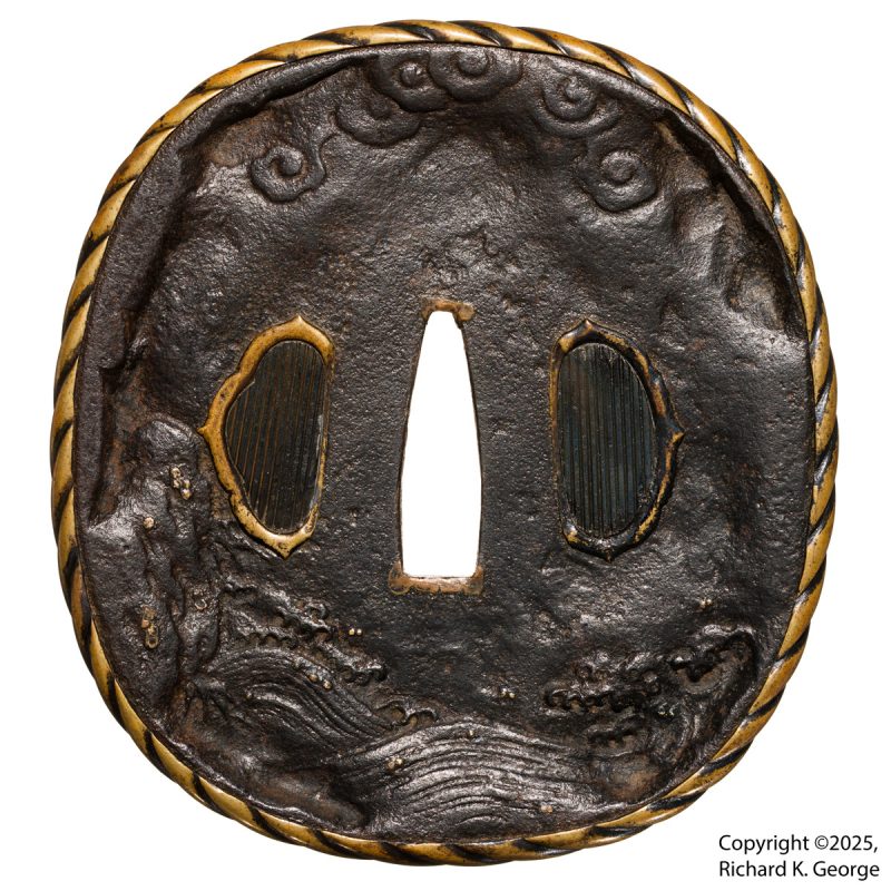 This tsuba is a bit of a beast.  It is made of iron with brass inlay and a brass mimi.  It measu ...